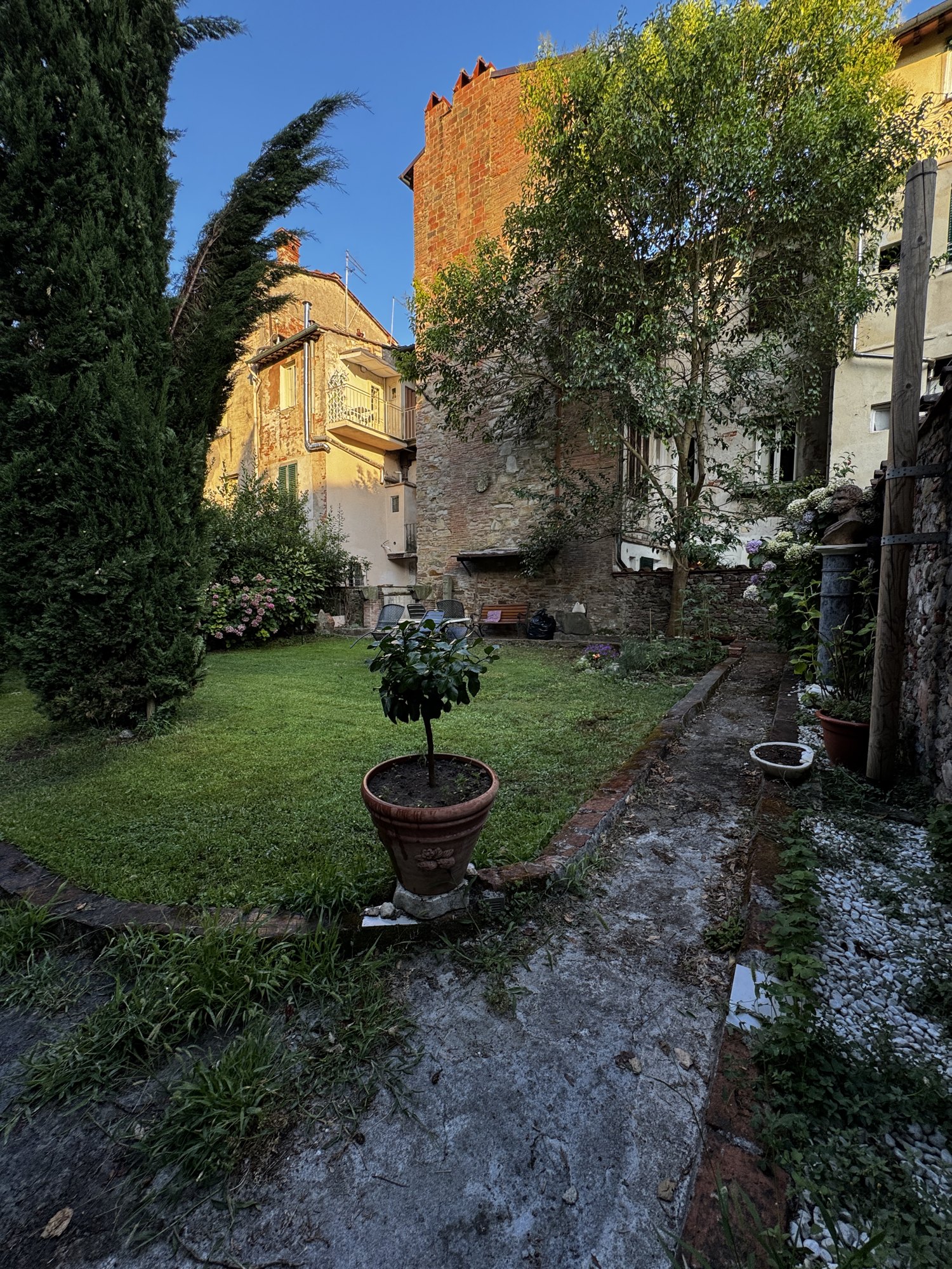 Il giardino privato di I Gelsi di Lucca con cipressi, prato e antiche mura